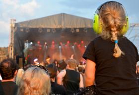 Niño con protectores de oídos durante un concierto.