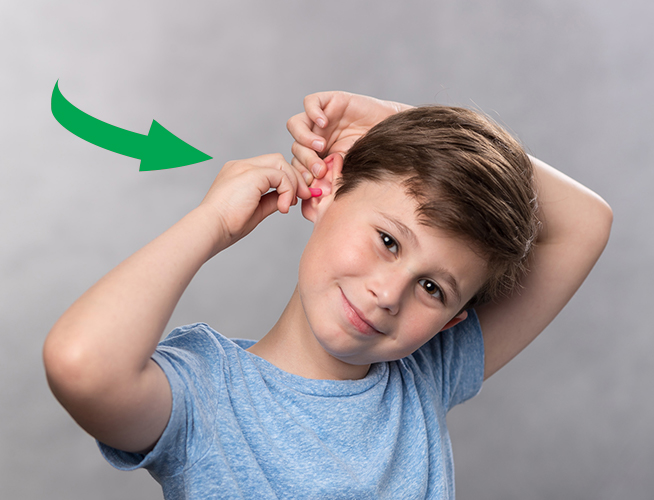 Screenshot of a GIF depicting young boy inserting a foam earplug.