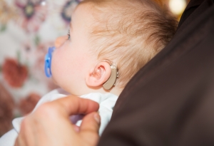 A baby with hearing aids.