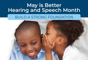 A young girl whispers into a boy's ear. Text reads: May is Better Hearing and Speech Month. Build a Strong Foundation.