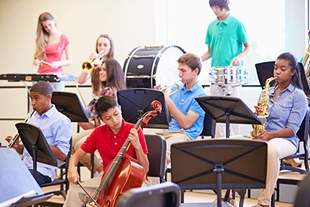 Teens in an orchestra playing instruments