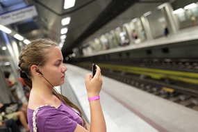 Girl in subway station wearing earbuds