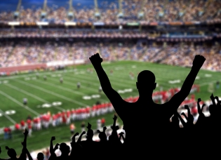 A fan cheering in the stands during a football game