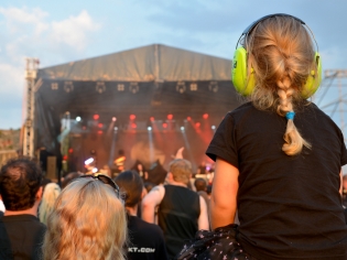 Child with ear muffs on at concert