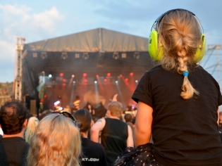 Niña en un concierto usando orejeras.