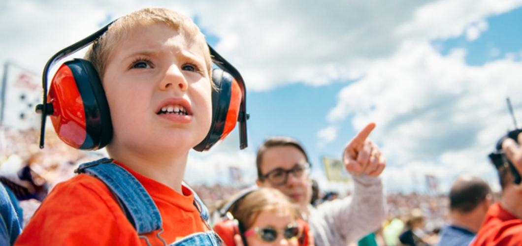 Young child with protective earmuffs at sporting event