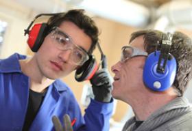 two factory workers wearing hearing protection