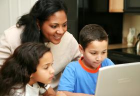 Woman and children looking at a computer screen together